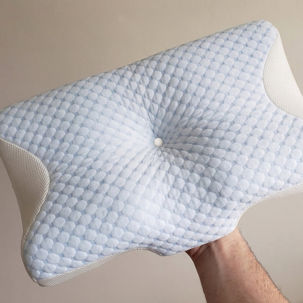 A customer holding up the Serenium Relief Pillow, contour visible
