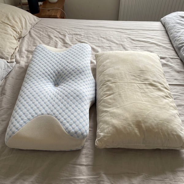 The Serenium Relief Pillow next to a flattened, yellowed old pillow