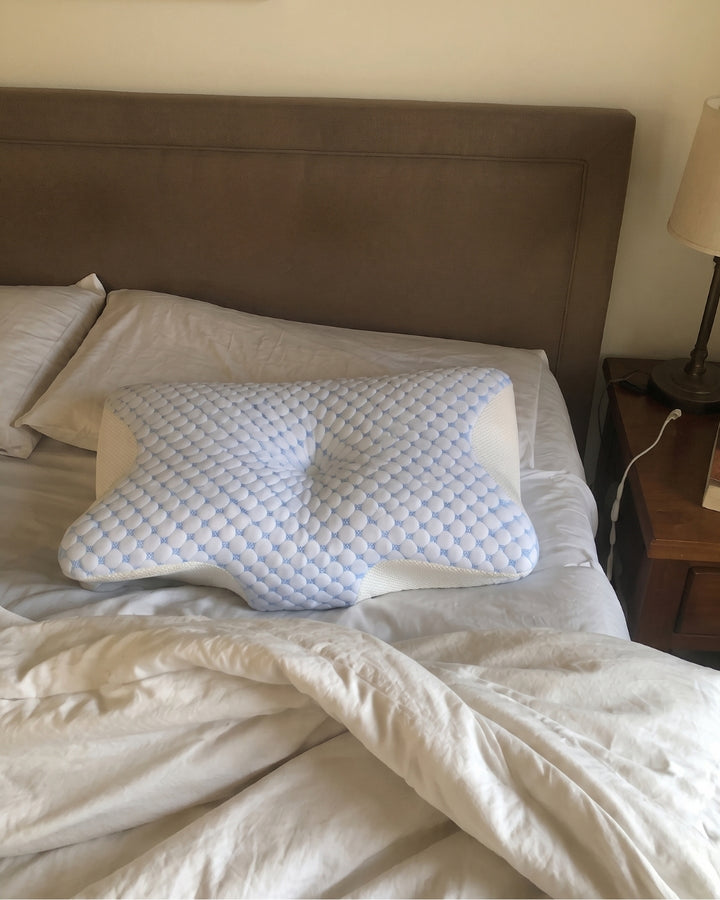 The Serenium Relief Pillow on a made bed